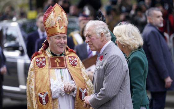 The prelate, vested, smiles at the King. 