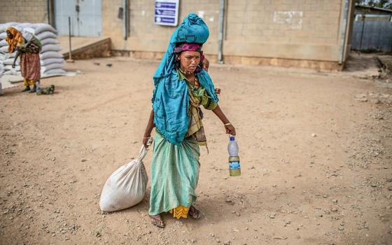 A woman carries home her rations of wheat, yellow split peas and cooking oil following a distribution of U.S. Agency for International Development (USAID) food in a rural area of Ethiopia's Oromia region Feb. 9, 2019. (OSV News/Courtesy of CRS/Will Baxter)