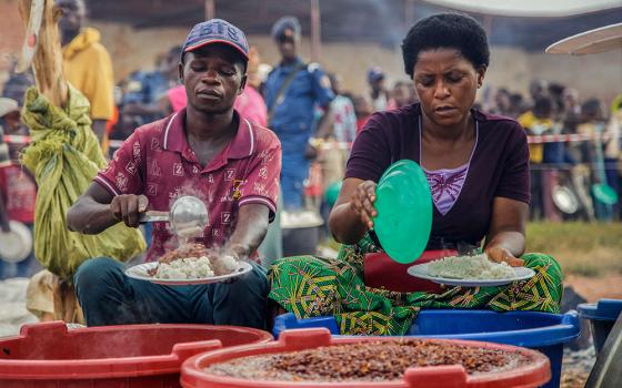 Burundian volunteers serve food to displaced families at Rugombo Stadium in Burundi, Feb. 18, 2025, after Congolese fled from renewed clashes between M23 rebels and the armed forces of the Democratic Republic of the Congo. (OSV News/Reuters/Evrard Ngendakumana)