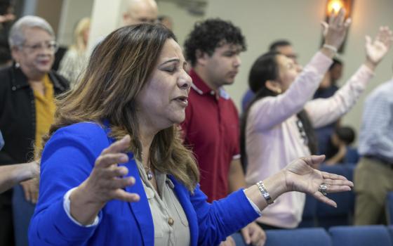 Guzman stands with hands raised outward. 