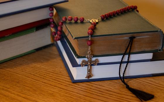 2 stacks of books with a rosary(NCR photo/Teresa Malcolm)