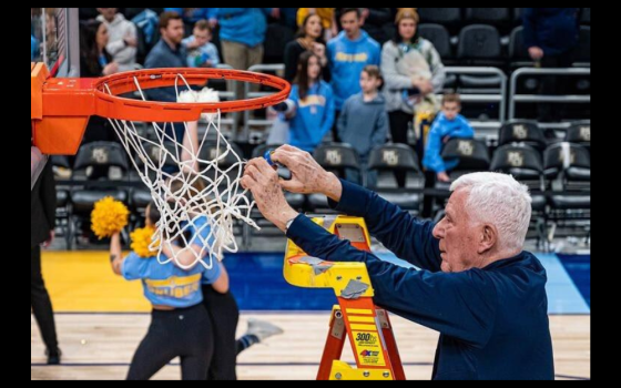 Marquette University basketball chaplain John Laurance cuts the net in Madison Square Garden after the Golden Eagles men’s basketball team won the Big East Tournament in 2023. (Courtesy of Marquette Athletics)