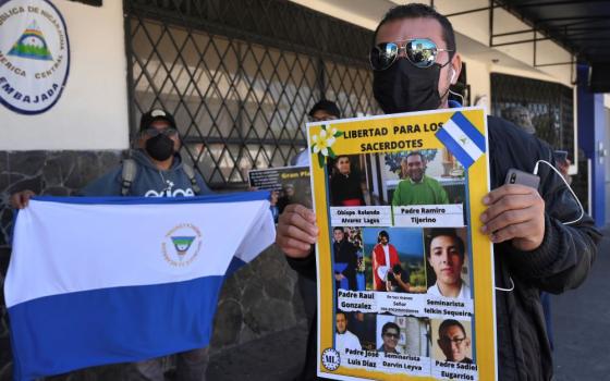 A Western Democratic Movement activist holds a poster with a message that reads in Spanish; "Free the priests."