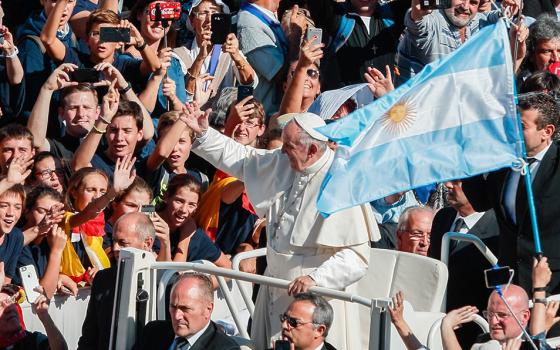 Argentina's flag is seen as Pope Francis greets the crowd after celebrating a canonization Mass for seven new saints in St. Peter's Square at the Vatican Oct. 16, 2016. Among those canonized was Argentine St. José Gabriel del Rosario Brochero, known as the "gaucho priest." (CNS/Paul Haring)