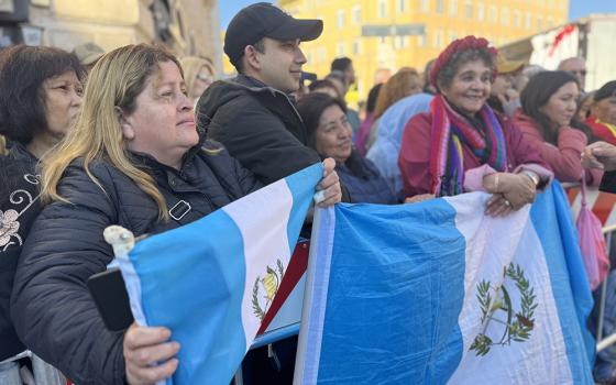 A group of Guatemalan migrants to Italy hold the flag of their country near the Basilica of St. Mary Major in Rome April 26, 2025, just before the arrival of Pope Francis' coffin. They said they feel they have not only lost a religious leader but also a friend and defender. (NCR photo/Rhina Guidos) 