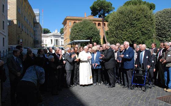 Pope Francis stands outside of Casa Santa Marta with attendees of a Pontifical Academy of Sciences meeting on the environment and climate change, in May 2014. Dan Misleh's head appears above the woman in the blue blazer to the right of Francis. (Courtesy of Dan Misleh)