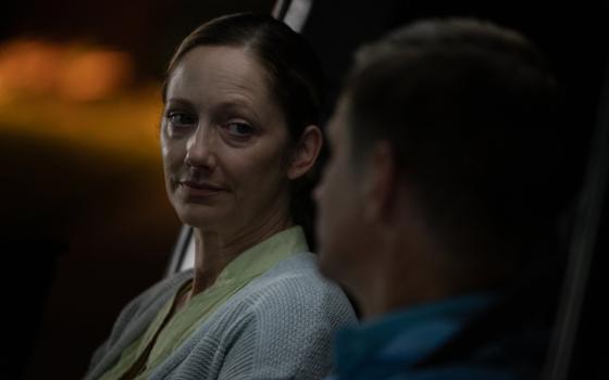 Judy Greer as Janice sits in a dimly lit car.