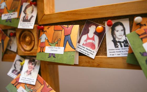 A cross outside the U.S. bishops' Office of Child and Youth Protection is covered with photos and prayers for the victims of clergy sexual abuse in a 2011 file photo. (CNS/Nancy Wiechec)