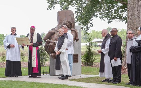 Charleston Bishop Jacques Fabre-Jeune (second from left) leads the blessing of the sculpture "Thy Father's Hand," by artist Garland Weeks, on April 26, 2025, in the new Meditation Garden of Truth and Reconciliation at Mepkin Abbey in Moncks Corner, South Carolina. (NCR screenshot/YouTube/Mepkin Abbey)