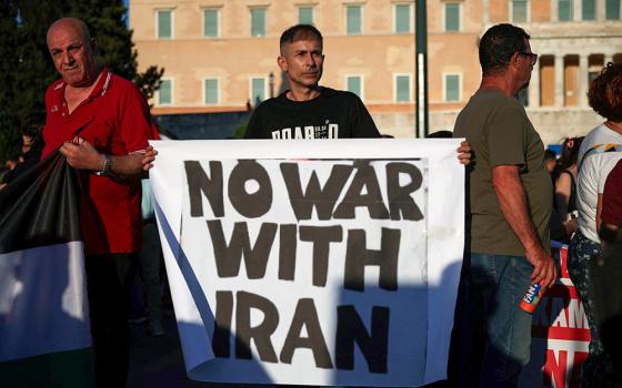 A demonstrator holds a sign during a protest over U.S. strikes on nuclear sites in Iran, in Athens, Greece, June 23, 2025. (OSV News/Reuters/Louiza Vradi)