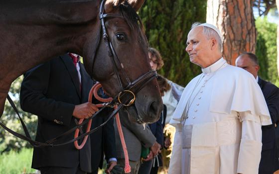 Pope Leo XIV looks at a horse as he greets farm workers in the papal gardens in Castel Gandolfo, Italy, Sept. 5, 2025. The pope inaugurated Borgo Laudato Si' the same day, officially opening the historic papal residence as a center dedicated to the principles of care for creation and human dignity outlined in Pope Francis' encyclical Laudato Si'. (CNS/Lola Gomez)