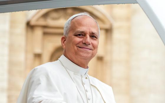 Pope Leo XIV smiles as he greets visitors and pilgrims from the popemobile under the rain in St. Peter’s Square at the Vatican before his weekly general audience Sept. 10, 2025. (CNS/Lola Gomez)