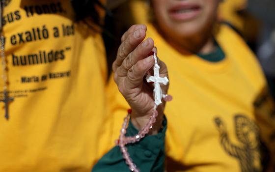 A woman holds a rosary as members of a Catholic group take part in a Eucharistic procession near the U.S. Immigration and Customs Enforcement (ICE) Broadview facility in Chicago Oct. 11, 2025. The group had hoped to share holy Communion with detainees at the facility. (OSV News/Reuters/Jeenah Moon)
