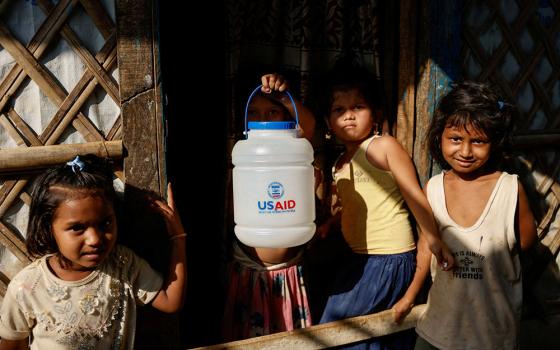 A Rohingya refugee girl holds a jar with U.S. Agency for International Development logo imprinted, at the refugee camp in Cox's Bazar, Bangladesh, March 16, 2025. The Trump administration moved March 28 to formally close USAID and fold remaining functions into the State Department. (OSV News/Reuters/Mohammad Ponir Hossain)