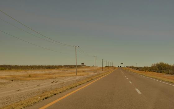 A highway lined with power lines in a brown landscape in Mexico (Unsplash/Andrea Brambila)