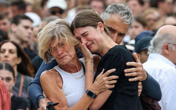 A woman cries as she pays her respects at Bondi Pavilion Dec. 15, 2025, to victims of a shooting during a Jewish holiday celebration at the beach in Sydney. Two gunmen opened fire during a Hanukkah celebration on Sydney’s Bondi beach Dec. 14, killing 15 people, including a child, officials said. (OSV News/Reuters/Hollie Adams)