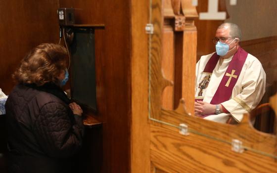 Fr. Manuel Rodríguez listens to a parishioner's confession at Our Lady of Sorrows in the Queens borough of New York on Saturday, March 20, 2021. (AP/Jessie Wardarski)