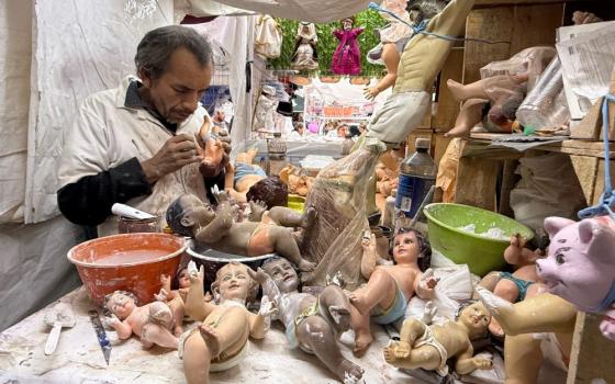 An artisan repairs a Baby Jesus figurine at a Mexico City market Jan. 27. Other damaged figurines await plaster and paint to prepare them for presentation at church on Candlemas, celebrated Feb. 2. (Anita Snow)