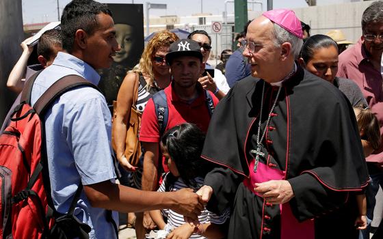 Bishop Mark J. Seitz of El Paso, Texas, greets a Salvadoran migrant in Ciudad Juarez, Mexico, June 27, 2019, who was deported after crossing the Paso del Norte international border from El Paso. (OSV News/Reuters/Jose Luis Gonzalez)