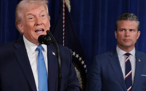 U.S. President Donald Trump speaks from Trump's Mar-a-Lago club in Palm Beach, Florida, 2026, as Secretary of Defense Pete Hegseth looks at him during a news conference following a U.S. strike on Venezuela where President Nicolás Maduro and his wife, Cilia Flores, were captured. (OSV News/Reuters/Jonathan Ernst)