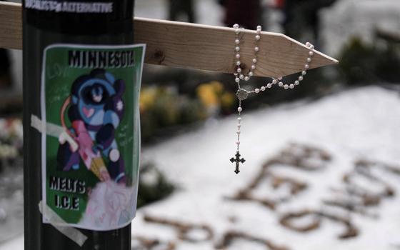 A rosary hangs from a cross at a makeshift memorial in Minneapolis Jan. 25, 2026, at the site where Alex Pretti, a 37-year-old intensive care nurse, was fatally shot by federal agents Jan. 24. (OSV News/Reuters/Tim Evans)