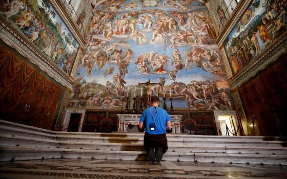 A visitor kneels in front of "The Last Judgement" fresco by the Italian Renaissance painter Michelangelo inside the Sistine Chapel in Rome, May 3, 2021. (AP/Alessandra Tarantino, file)