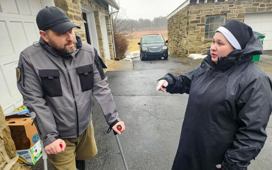 Basilian Sr. Anna Andrusiv, right, who arrived in Jenkintown in September after taking final vows in the Ukrainian capital of Kyiv in August, speaks to Ihor Kozak, 40, a Ukrainian soldier undergoing medical treatment at the University of Pennsylvania hospitals. (GSR photo/Chris Herlinger)
