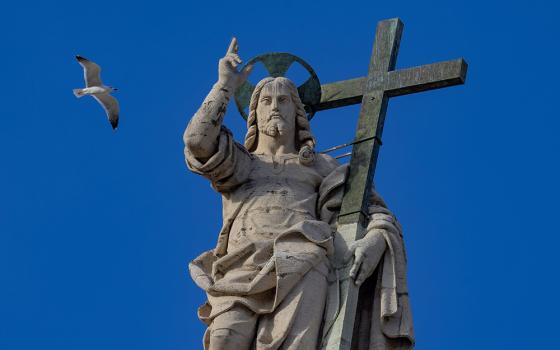 A bird flies over the statue of the Risen Christ on top of the facade of St. Peter's Basilica at the Vatican during Pope Francis' weekly general audience Nov. 13, 2024. (CNS/Pablo Esparza)