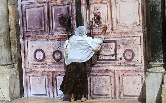 An Ethiopian Christian woman prays at the locked doors of the Church of the Holy Sepulcher in the Old City of Jerusalem March 4, 2026, on day five of the U.S.-Israel war with Iran. The church and other religious sites as well as stores were locked shut by order of the Israeli government as Iranian ballistic missiles were fired at Israel. (OSV News/Debbie Hill)