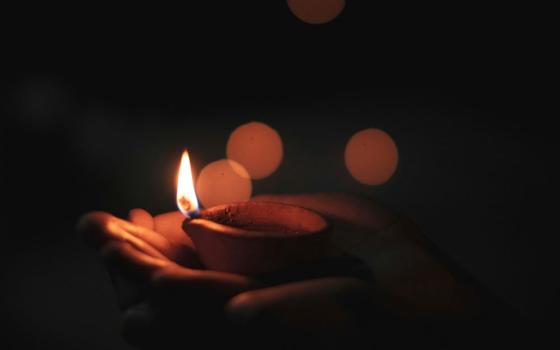 hands hold Diwali candle 