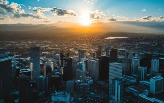 The sun sets behind the Denver skyline. (RNS/Unsplash/Nils Huenerfuerst)