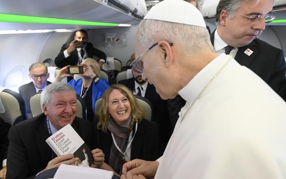 2 Elisabetta Piqué and Gerard O'Connell give a Spanish-language edition of their book, The Election of Pope Leo XIV: The Last Surprise of Pope Francis, to Leo during a flight from Rome to Ankara Nov. 27, 2025. (Courtesy of Gerard O'Connell and Elisabetta Piqué)