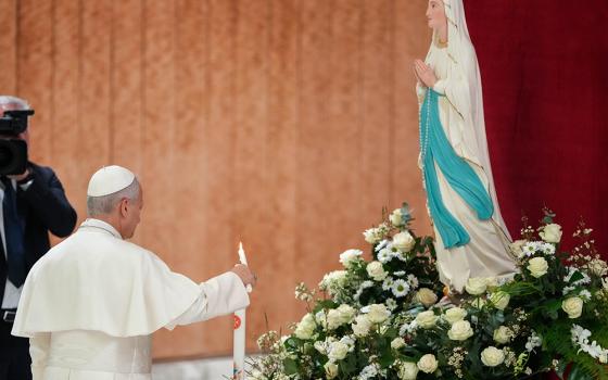 Pope Leo XIV lights a candle and prays before an image of Our Lady of Lourdes prior to his weekly general audience in the Paul VI Audience Hall at the Vatican Feb. 11, 2026. (CNS/Lola Gomez)