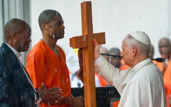 Pope Leo XIV receives a cross from an inmate during the pontiff's visit to Bata prison in Equatorial Guinea, April 22, 2026. (OSV News/Reuters/Guglielmo Mangiapane)