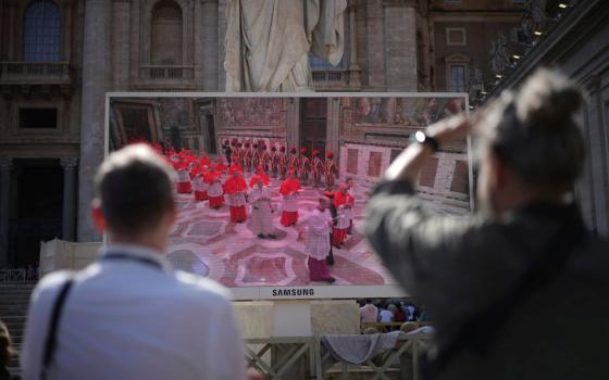 Faithful watch a giant screen showing images of cardinals entering the conclave, in St. Peter’s Square at the Vatican, May 7, 2025. (RNS/AP/Andrew Medichini)