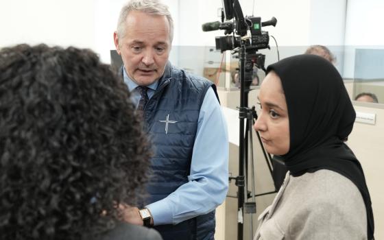 J. Antonio Fernández, CEO of Catholic Charities of the Archdiocese New York, and Faiza Ali, commissioner at the New York City Mayor's Office of Immigrant Affairs York, visit booths where volunteers held an immigration information phone bank to offer guidance and respond to local immigrants' concerns April 21. (Courtesy of Catholic Charities of the Archdiocese of New York)