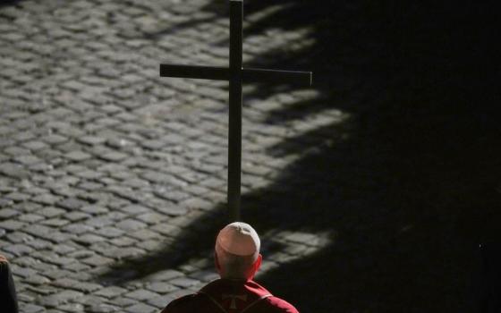 Pope Leo XIV carries a lightweight, 5-foot wooden cross during the Via Crucis, the torchlit Good Friday Stations of the Cross procession at the Colosseum in Rome April 3. The Stations of the Cross symbolically retrace Jesus Christ's steps to his crucifixion on Calvary in Jerusalem. (AP/Alessandra Tarantino)