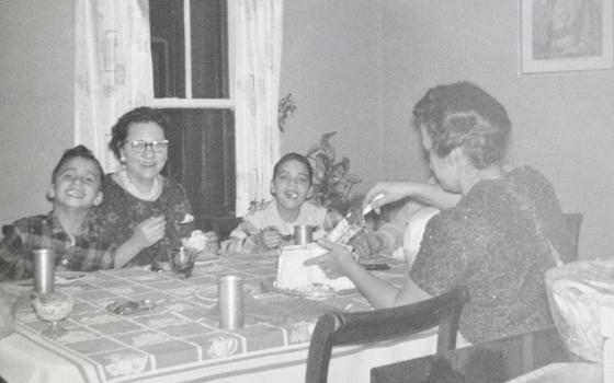 In this undated photo, Pope Leo XIV (then Robert Prevost, left) smiles while his mother (back to the camera) cuts a birthday cake in what his brother (right) guessed was the pope's ninth birthday, at the family home in the Chicago suburb of Dolton. (OSV News/Prevost family)