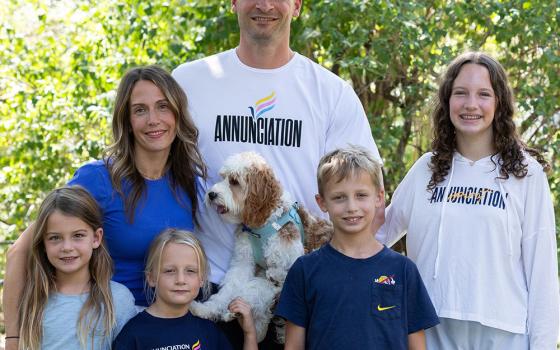 The Stommes family gathers for a photo in the front yard of their home in Minneapolis: front left, Esme, Etta and Finnegan; back left, Molly, Matt (holding Louie) and Charlize. The family lives across the street from Annunciation Church and School in Minneapolis. (OSV News/The Catholic Spirit/Dave Hrbacek)