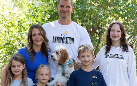 The Stommes family gathers for a photo in the front yard of their home in Minneapolis: front left, Esme, Etta and Finnegan; back left, Molly, Matt (holding Louie) and Charlize. The family lives across the street from Annunciation Church and School in Minneapolis. (OSV News/The Catholic Spirit/Dave Hrbacek)