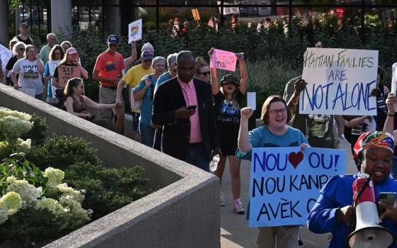 Mia Perez, right, with Voices of Immigrants organization, leads a march as community leaders and residents gather for a rally at City Hall in support of Haitians Aug. 16, 2026, in Springfield, Ohio. (RNS/Carol Guzy)