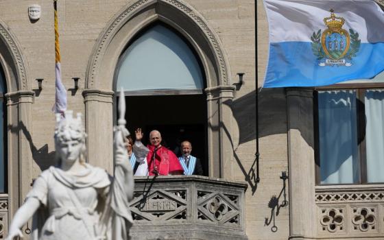 Pope Leo XIV, flanked by Captains Regent Alice Mina, left, and Vladimiro Selva, waves to faithful from the balcony of Palazzo Pubblico (City Hall) during his visit to San Marino Aug. 22, 2026. (AP/Andrew Medichini)