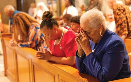 Black Catholic women in prayer at Mass