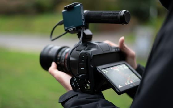 Hands operating a camera.