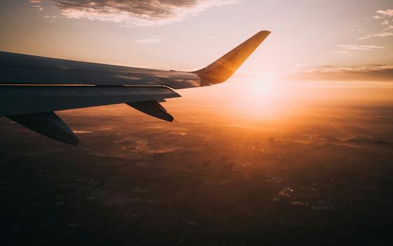 The sun is seen in a shot of a town's horizon, which looks to taken from an airplane (Unsplash/Nils Nedel)