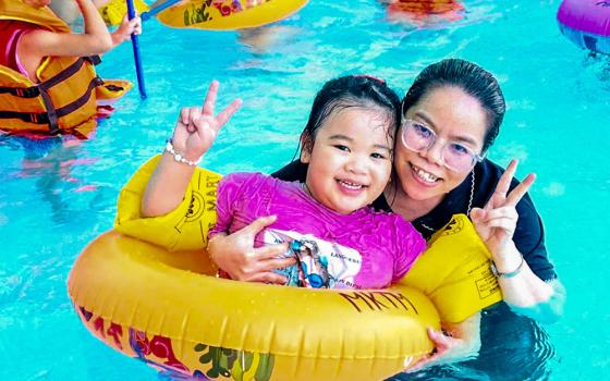 Sr. Mary Nguyen Hong Vy poses with a child after a water safety lesson at a pool in Hue, Vietnam, on July 10, 2026. (Joachim Pham)