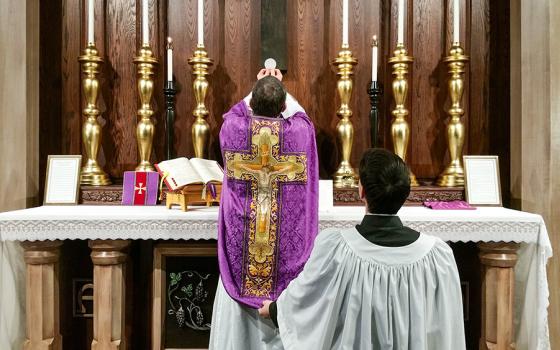 A priest elevates the Eucharist during a Latin Mass. (RNS/Andrew Gardner/Creative Commons)