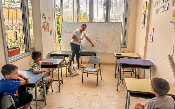 A teacher at Holy Family Parish's school in Gaza City is seen July 22, 2024, in a classroom with children as part of the St. Joseph educational project for the 150 Christian youth sheltering at the parish compound and at the nearby Greek Orthodox church compound. (OSV News/Courtesy of Gabriel Romanelli)