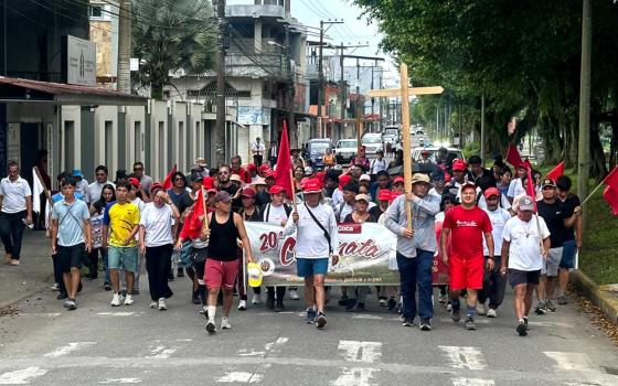 Bishop Adalberto Jiménez, apostolic vicariate of Aguarico, Ecuador, carries a cross on a pilgrimage from Quito to Coca, Ecuador, in honor of Bishop Alejandro Labaka Ugarte and Sr. Inés Arango Velásque. (Courtesy of Sr. Winifred Doherty)