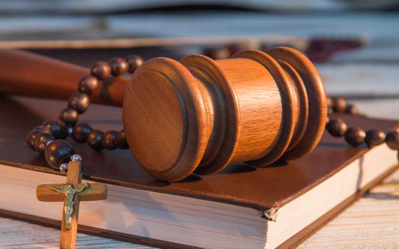 Gavel, law book and a rosary (Dreamstime/Denys Kovtun)